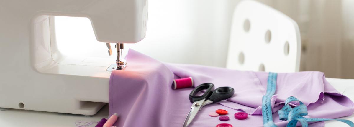 ピンク色の生地の上に裁縫道具が置かれている