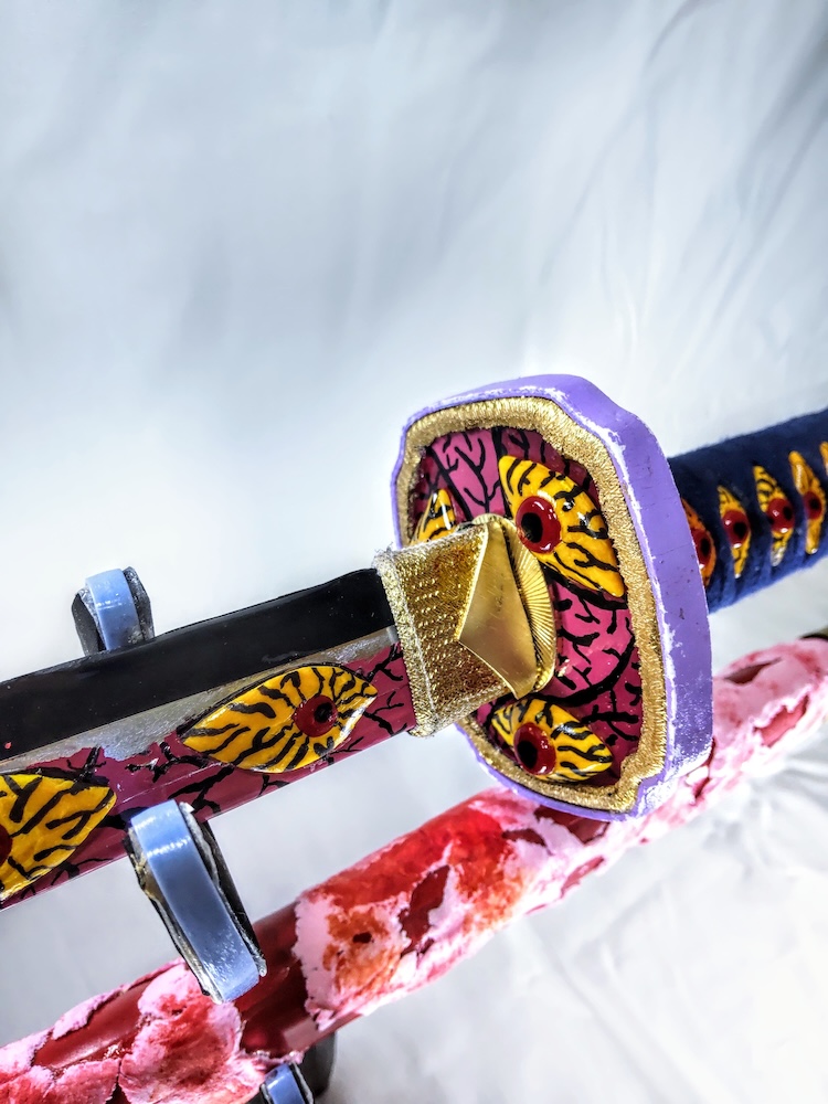 目玉がついて鍔と目玉のついた刀身とピンクと赤色に包まれた鞘