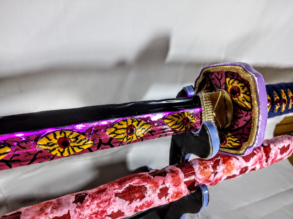 刀身の間から光る紫色のライトと鍔