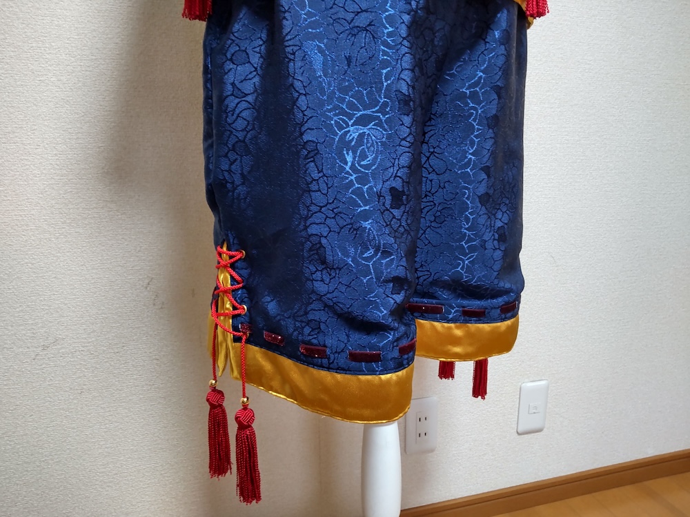 製作した日白残無の赤いタッセルがぶら下がった青い半ズボン