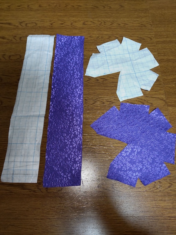 紫色の布生地を型紙通りに裁断した後