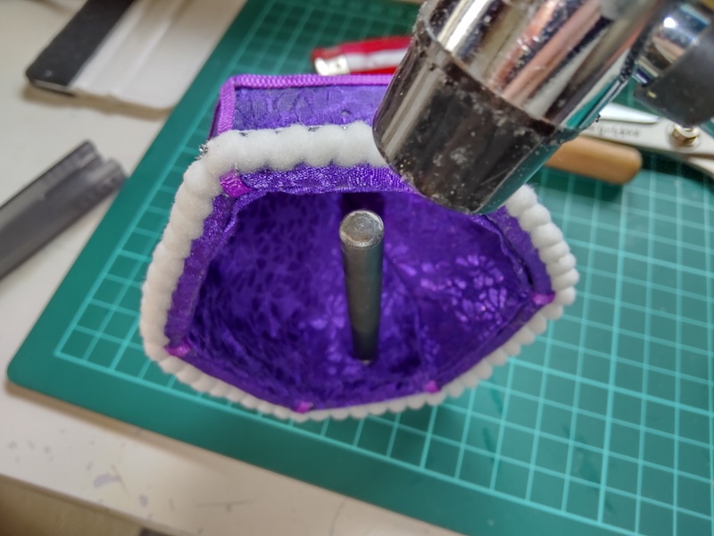 100均のベルト通しとトンカチを使って紐通し用の穴を開ける