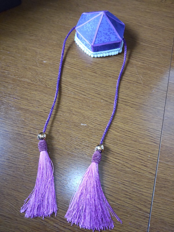 紐を通して先端にタッセルとループエンドをつけた頭襟