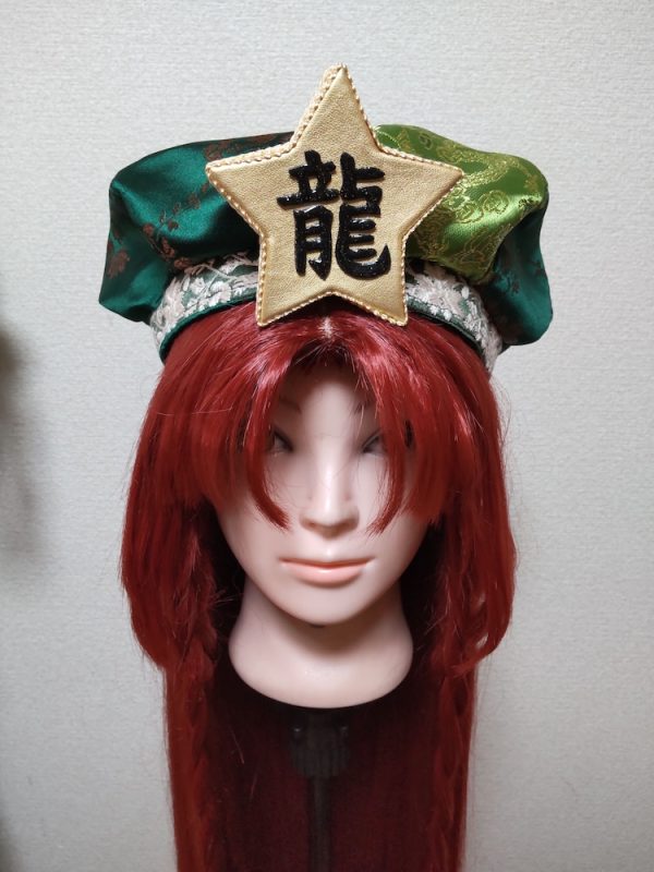 前髪を上げて三つ編みしたウィッグと「龍」の文字が入ったキャスケット帽子