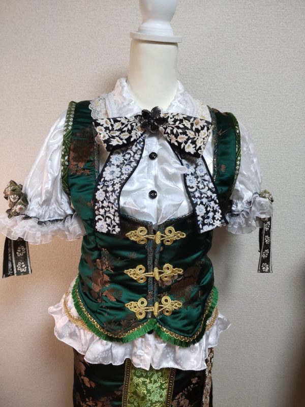 胸元にインド刺繍のリボンがついた白ブラウスと花柄のチャイナ風ジャケット