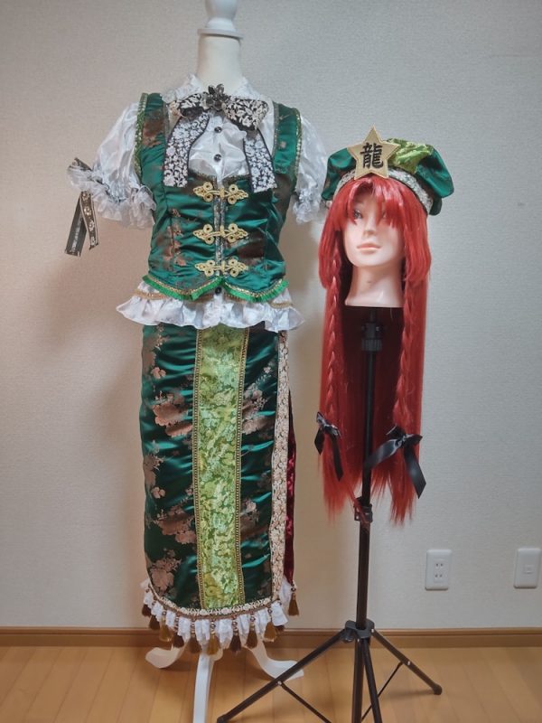 白いブラウスに緑色のジャケットとチャイナスカート
三つ編みのウィッグに「龍」の文字が入った帽子