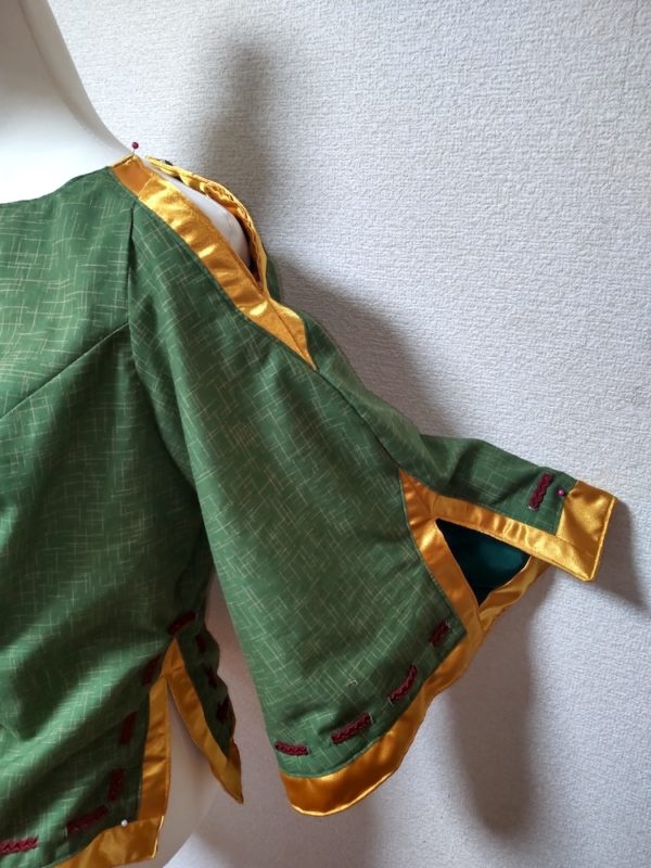 緑をベースにしたブラウスに形に金色のスリットが入った袖
